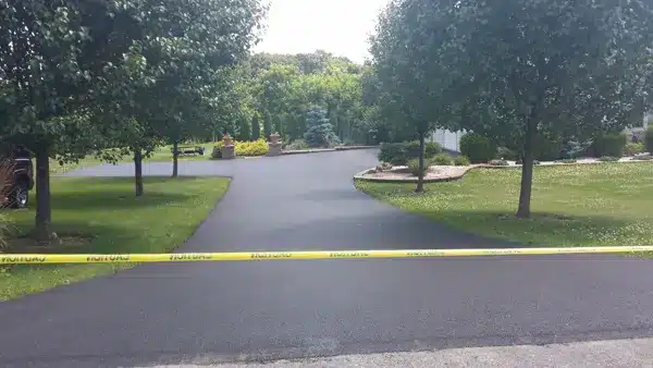 after image of asphalt paved driveway, caution tape placed